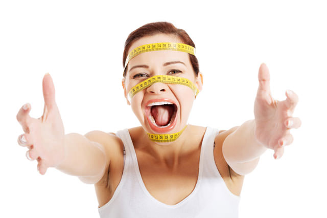 Beautiful woman's face with measuring tape.