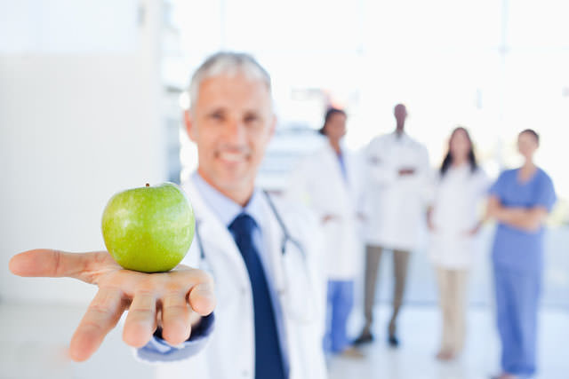 bigstock-Green-apple-held-by-a-doctor-w-39323254