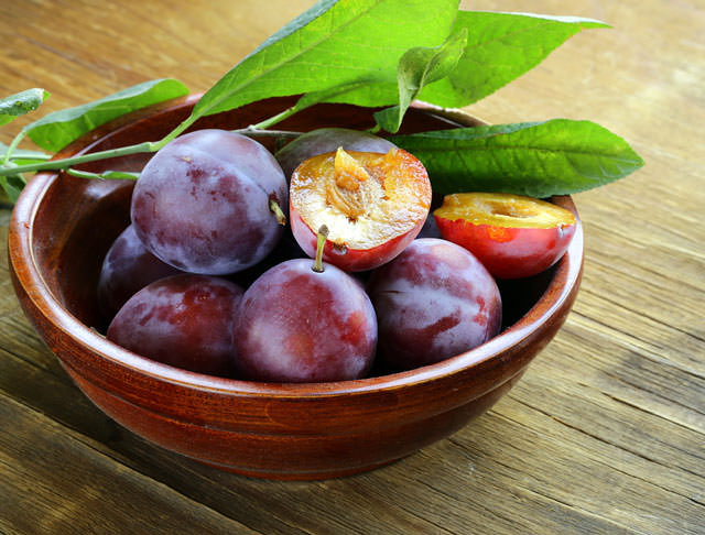 bigstock-ripe-purple-plums-on-a-wooden--50164028