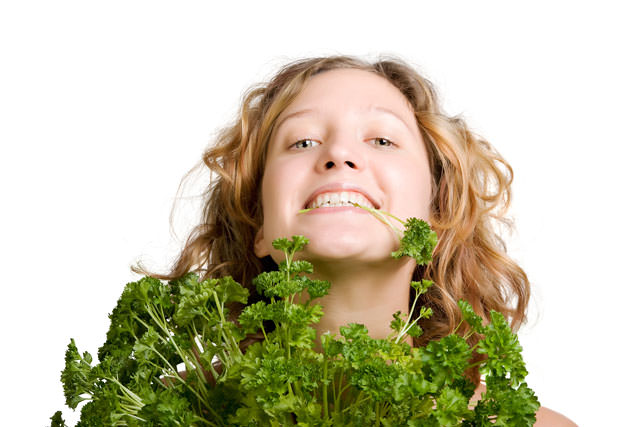 Young smiling woman with fresh parsley