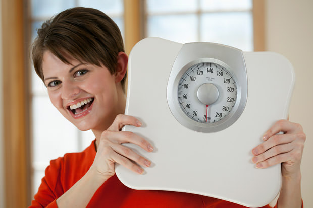 Attractive Woman Holding a Bathroom Scale